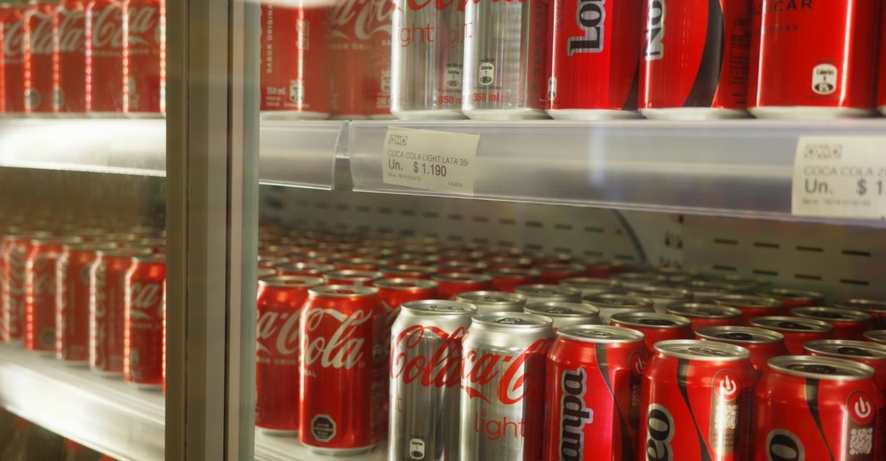 Koeling met rijen frisdrankblikjes in een winkel