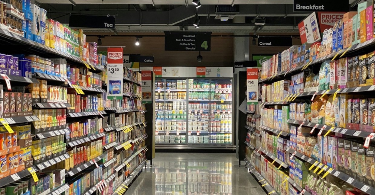 Supermarktgangpad met gevulde schappen