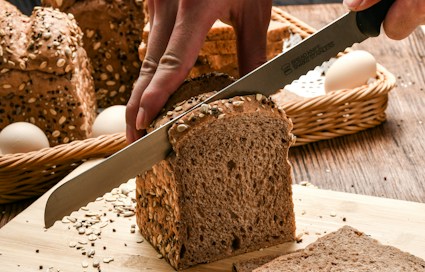 Volkorenbrood met zaden wordt aangesneden op een snijplank